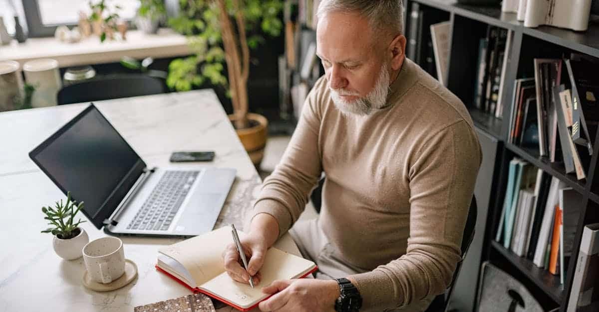 A man in his late 40s sitting at his home desk writing in a journal, natural morning light, calm and contemplative. Illustrates the diagnostic first step of a midlife reset.